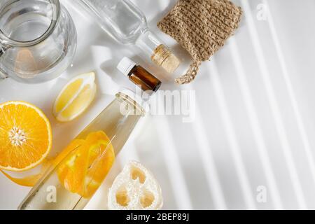 Allzweckreiniger aus natürlichen Zutaten, Weißessig, Wasser, Zitronenschale und Aromaöl. Bio-Waschmittel in einer Glasflasche. Platz für Ihr Stockfoto