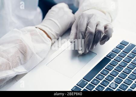 Bio-Gefahr Mann mit Laptop. Geschäftsmann, der in Quarantäne an einem Laptop arbeitet. Stockfoto