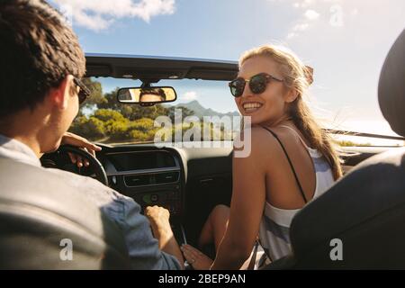 Schöne Frau geht auf eine Roadtrip mit ihrem Freund. Ein Paar fährt in einem Cabrio lange. Stockfoto