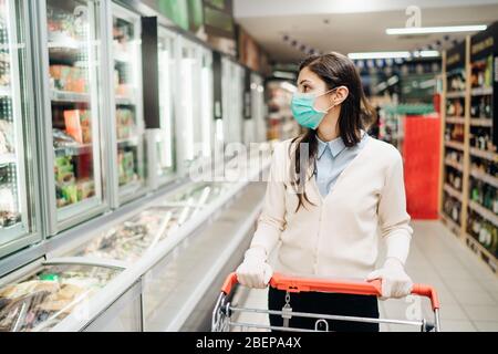 Shopper mit Maske sicher für Lebensmittel kaufen aufgrund der Coronavirus Pandemie im Lebensmittelgeschäft.COVID-19 Shopping.Quarantäne Vorbereitung.Panik Kauf und s Stockfoto