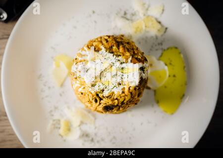 Gelbes Kurkuma-Risotto mit wilden Steinpilzen Platte serviert mit Rotwein.Safranreis mit Parmesan-Käse.Italienische traditionelle Rezepte aus nächster Nähe. Stockfoto