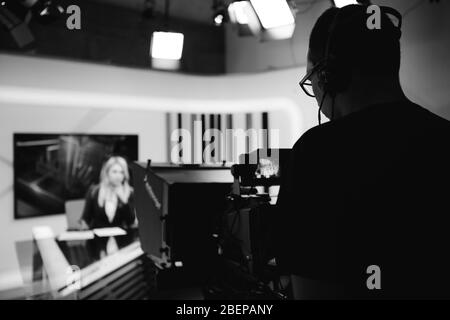 Aufnahme im TV-Nachrichtenstudio positioniert Kamera-Ausrüstung mit TV-Moderator Journalist Berichterstattung weltweit.TV Ansager während Live-Broa Stockfoto