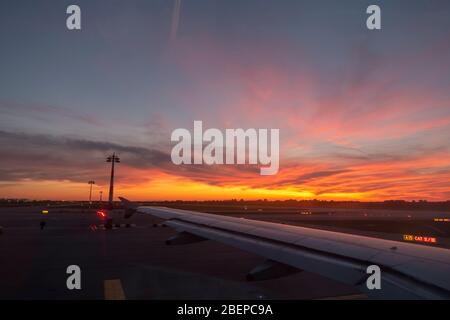 Schöner Sonnenuntergang über einem Flugzeugflügel bei einem Flugzeug, das vom Flughafen München, München, Bayern, Deutschland abfliegt. Stockfoto