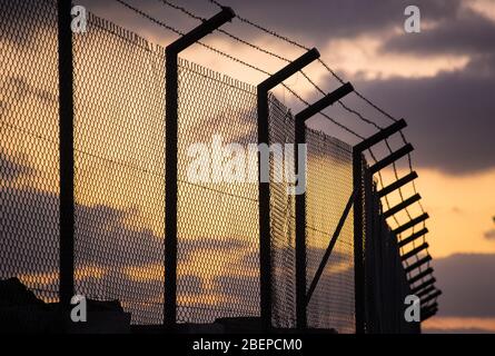 Stachelzaun Sonnenuntergang gegen niedrige Wolke 2 von 2 Stockfoto