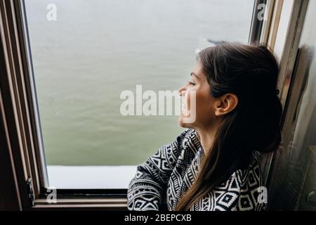 Junge Frau verbringen Freizeit Home.Self Pflege, zu Hause bleiben.Genießen Aussicht, Blick durch das window.Quarantined Person indoor.Serene Mornings.avoid Stockfoto