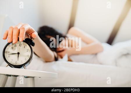 Wecker klingelt.Frau am frühen Morgen für die Arbeit aufwachen.Obstruktive Schlafapnoe Effekte.psychische Belastung Schlaf Depression.Melatonin Mangel.Narc Stockfoto