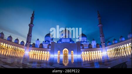 Nachts Panoramablick auf die Scheich Zayed Moschee. Blick auf die Scheich Zayed Moschee mit Kuppeln, Bögen und Lichtern. Stockfoto