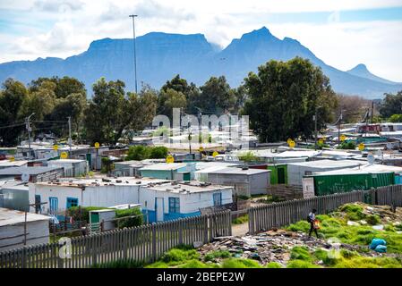 Township Hütten in Khayelitsha am Rande von Kapstadt. Üppige Berge ruhen im Hintergrund. Satellitenschüsseln sind üblich und die meisten Hütten haben Strom. Stockfoto