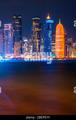 Die Wolkenkratzer des neuen West Bay Doha Stadt von Al Corniche am Abend gesehen. Stockfoto