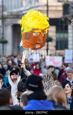 Mann, der einen Papiermaché-Kopf von Donald Trump beim Frauenmarsch 2017 in London hochhält Stockfoto