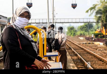 Bandung, Indonesien. April 2020. Passagiere mit Schutzmaske warten auf einen Zug an einem Bahnhof während der Ausbreitung der Coronavirus-Krankheit (COVID-19) Ausbruch in Bandung, West Java, Indonesien, 15. April 2020. (Foto von Agvi Firdaus/INA Photo Agency/Sipa USA) Quelle: SIPA USA/Alamy Live News Stockfoto