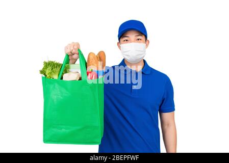 Hygienischer Mann trägt medizinische Maske hält Supermarkt Lebensmittel Einkaufstasche bietet Hauslieferdienst isoliert in weißem Hintergrund Stockfoto