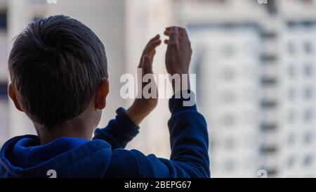 Kinder applaudieren vom Balkon, um medizinisches Personal, Gesundheitshelfer, Ärzte, Krankenschwestern während der Coronavirus-Pandemie zu unterstützen Stockfoto