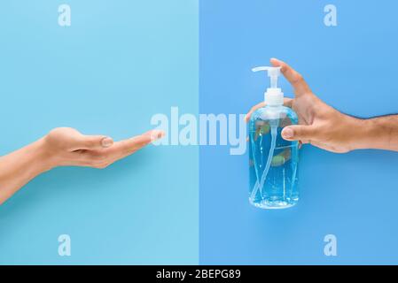 Man Hand Pumpen Alkohol Gel auf eine andere Hand zur Reinigung und zum Schutz vor Keimen und Viren Stockfoto