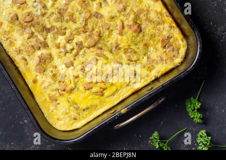 Cheesy, Speck und Würstchen, Frühstück Backen im Ofen Fach auf schwarzem Hintergrund - herzhafte Torte top Foto anzeigen Stockfoto