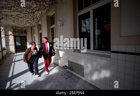 Leipzig, Deutschland. April 2020. Die Klinikclowns 'Ulla' und 'Herr Liebling' spielen vor den Fenstern des Nierenzentrums für Kinder und Jugendliche in der Klinik St. Georg in Leipzig. Die Clownsleistung ist die erste seit der koronabedingten Einschränkung. Seit etwa anderthalb Jahren treten die Klinikclowns Heiko Fischer und Marita Brauer, wie sie von ihren echten Namen genannt werden, in der Kinderklinik auf, in der Regel zweimal im Monat. In sicherer Entfernung bringen sie nun die kleinen Patienten vor den Fenstern zum Lachen. Foto: Hendrik Schmidt/dpa-Zentralbild/ZB Quelle: HE Stockfoto