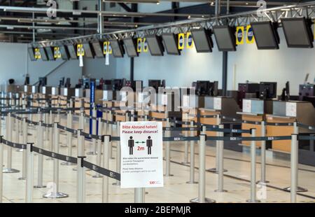 09. April 2020, Brandenburg, Schönefeld: Im Abflugterminal M des Flughafens Schönefeld werden Sperrbänder aufgebaut. Ein Schild am Eingang warnt vor dem Sicherheitsabstand von zwei Metern zwischen zwei Personen. Aufgrund der Gefahr durch die Ausbreitung von Covid-19 gibt es in vielen Ländern Einreisebeschränkungen und damit erhebliche Einschränkungen im Luftverkehr. Foto: Soeren Stache/dpa-Zentralbild/ZB Stockfoto
