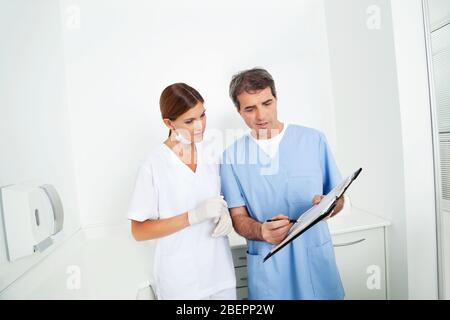 Zwei Ärzte beraten mit Blick auf ein Clipboard Stockfoto