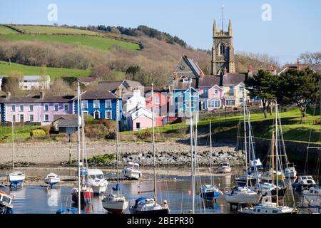 Blick entlang der Afon Aeron River Mündung zur Kirche mit Booten im Hafen bei einer Flut in attraktiven Küstenstadt festgemacht. Aberaeron Ceredigion Wales Stockfoto