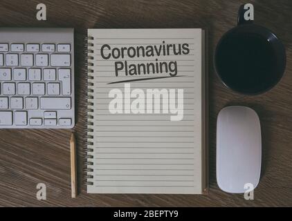 Ein Schreibtisch mit Notebook und Computer mit der Geschäftsplanung für die Zukunft und das vorausschauende Denken wegen Coronavirus mit Kopierraum Stockfoto