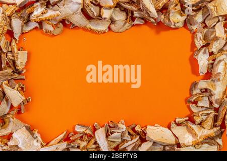 Getrocknete Shiitake Pilze auf orangefarbenem Hintergrund isoliert. Konzeptfoto. Stockfoto