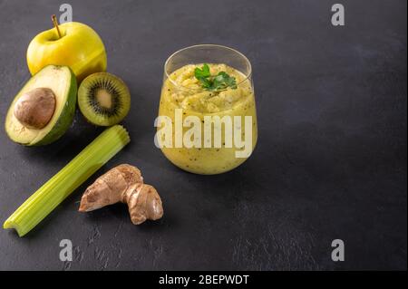 Frisch gemachter grüner Smoothie aus Gemüse, Obst, Kräutern und Grüns auf dunklem Hintergrund. Kopierbereich Stockfoto