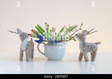 Zwei FilzHirche riechen an Ästen und Tulpen Stockfoto