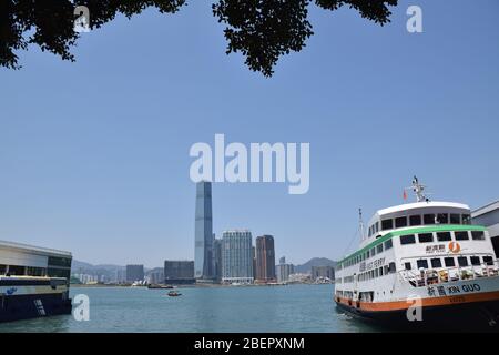 Eine Fähre im Meer und das International Commerce Centre (auch ICC genannt) vom Central Ferry Pier - Hong Kong Stockfoto