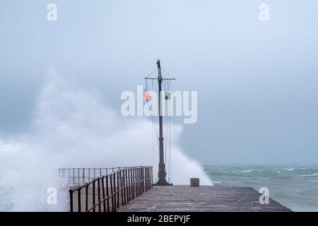 Ein stürmischer Wintertag mit Wellen, die den Hafen in Porthleven, Cornwall England, überfluten Stockfoto