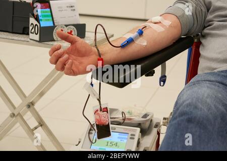 Koblenz, Deutschland. April 2020. Ein Mann spendet Blut im Atrium der Rhein-Mosel-Halle, wo üblicherweise Veranstaltungen stattfinden. Die Blutspender werden vom Deutschen Roten Kreuz (DRK) in größeren Räumen mit mehr Raum zwischen ihnen aufgenommen, da das Infektionsrisiko durch die Corona-Pandemie besteht. Quelle: Thomas Frey/dpa/Alamy Live News Stockfoto