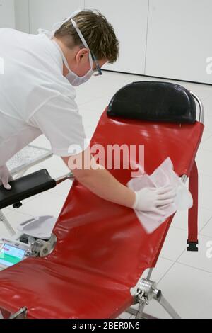 Koblenz, Deutschland. April 2020. Ein Mitarbeiter des DRK-Blutspendedienstes desinfiziert eine Behandlungstische im Atrium der Rhein-Mosel-Halle, wo üblicherweise Veranstaltungen stattfinden. Die Blutspender werden in größeren Räumen in größerer Entfernung voneinander empfangen, da das Infektionsrisiko durch die Corona-Pandemie besteht. Quelle: Thomas Frey/dpa/Alamy Live News Stockfoto