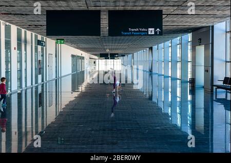 05/26/2019 Flughafen Bodrum / Flughafen Milas Mugla. Türkei. Kleines Mädchen, das Kart-Räder macht, übt aus Langeweile, während es auf ihren Flug wartet. Stockfoto