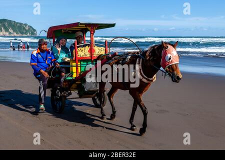 Ein älteres indonesisches Paar genießt EINE Kutschfahrt auf dem Parangtritis Beach, Yogyakarta, Indonesien. Stockfoto