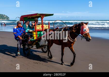 Ein älteres indonesisches Paar genießt EINE Kutschfahrt auf dem Parangtritis Beach, Yogyakarta, Indonesien. Stockfoto