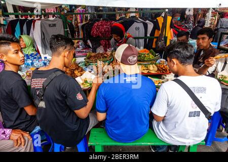 Junge Indonesier Männer essen Essen in EINEM Street Food Stall, Malioboro Street, Yogyakarta, Indonesien. Stockfoto
