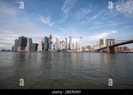 New york Skyline Reflexion auf dem Hudson River an der Brooklyn Bridge bei hellem Tageslicht Stockfoto
