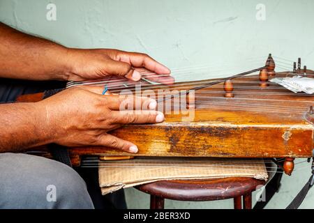 Ein Indonesier, der an EINEM Saiteninstrument, Yogyakarta, Java, Indonesien, zupft. Stockfoto