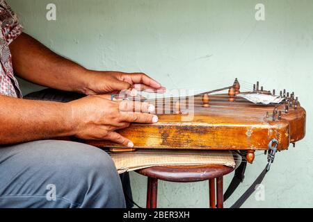 Ein Indonesier, der an EINEM Saiteninstrument, Yogyakarta, Java, Indonesien, zupft. Stockfoto