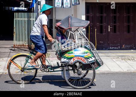 Eine einheimische Frau auf Reisen in EINEM traditionellen Becak (Cycle Rickshaw) Yogyakarta, Indonesien. Stockfoto
