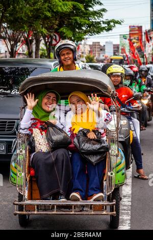Zwei Lächelnde Indonesische Frauen, Die Mit Dem Motorrad-Taxi In Yogyakarta, Indonesien Reisen. Stockfoto