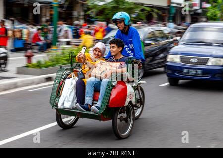 Ein Motorrad-Taxi und Passagiere, Malioboro Street, Yogyakarta, Indonesien. Stockfoto