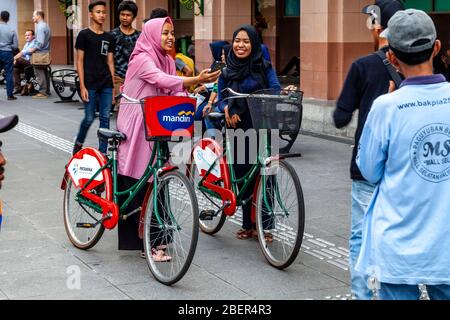 Zwei Indonesische Frauen Mit Ihren Fahrrädern In Der Malioboro Street, Yogyakarta, Java, Indonesien. Stockfoto