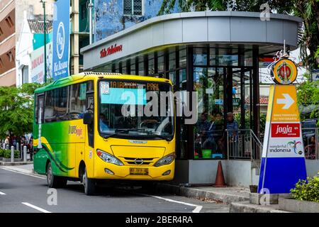 Ein lokaler Bus holt die Passagiere an einer Bushaltestelle in der Malioboro Street, Yogyakarta, Java, Indonesien ab. Stockfoto