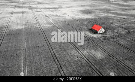 Einsame Isolation von der Gesellschaft in einem Haus mitten auf einem Feld Stockfoto