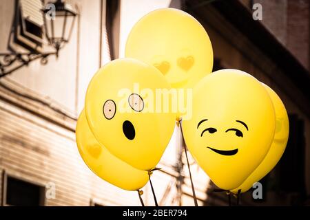 Gelbe Emoji Ballons schweben auf einer Straßenparty in Senigallia, Le Marche, Italien Stockfoto