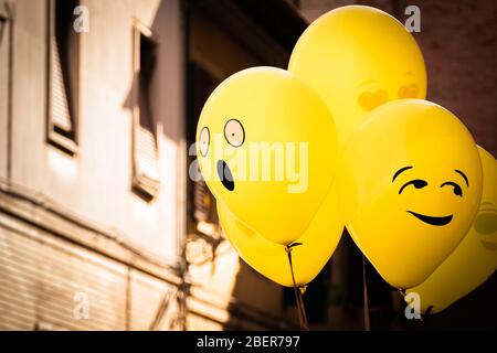 Fun gelbe Emoji Ballons schweben auf einer Straßenparty in Senigallia, Le Marche, Italien Stockfoto