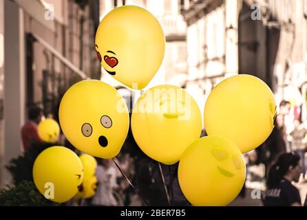 Fun gelbe Emoji Ballons schweben auf einer Straßenparty in Senigallia, Le Marche, Italien Stockfoto