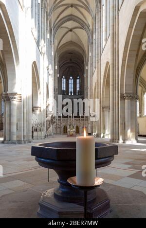 14. April 2020, Sachsen-Anhalt, Magdeburg: Eine Kerze brennt am Taufbecken des Doms. Foto: Stephan Schulz/dpa-Zentralbild/ZB Stockfoto