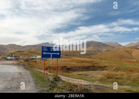 Ein Verkehrsschild, das die Richtung nach Bischkek und Osch im Suusamyr-Tal in Kirgisistan anzeigt. Stockfoto
