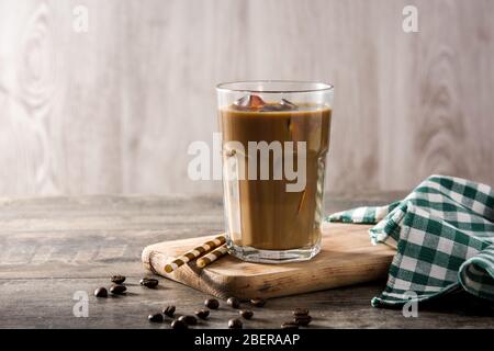 Iced Kaffee oder Caffe Latte in hohem Glas auf Holztisch. Stockfoto